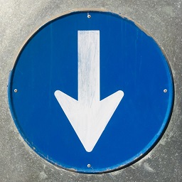 Photo of white downwards pointing arrow on blue background